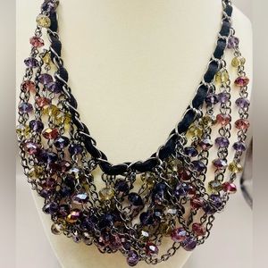 Purple and clear bead bib necklace with a silver interwoven with black ribbon.